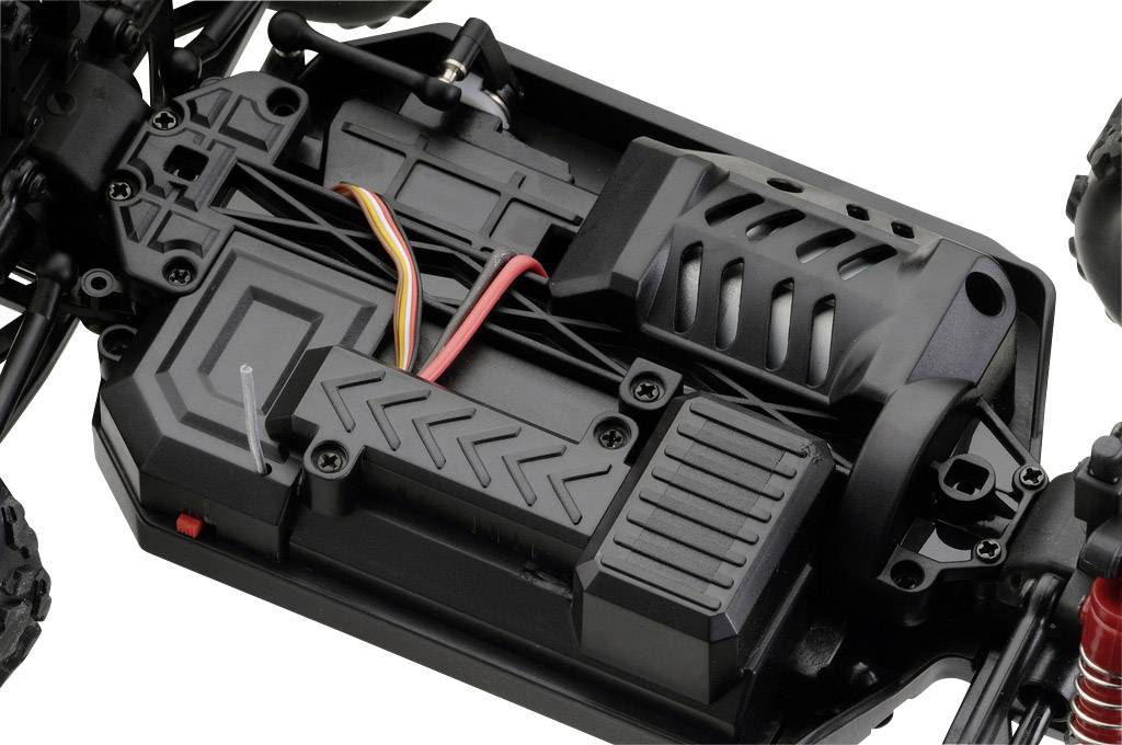 Nahaufnahme eines ferngesteuerten Elektrofahrzeugs. Sichtbar sind Akkufach, Motorgehäuse und einige farbige Kabel für die Elektronik.
