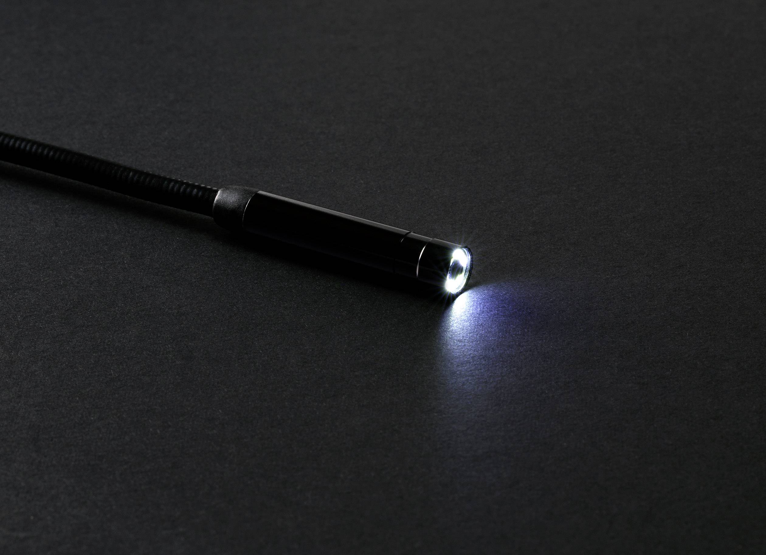 'Kleine Taschenlampe leuchtet auf dunklem, neutralem Hintergrund.'