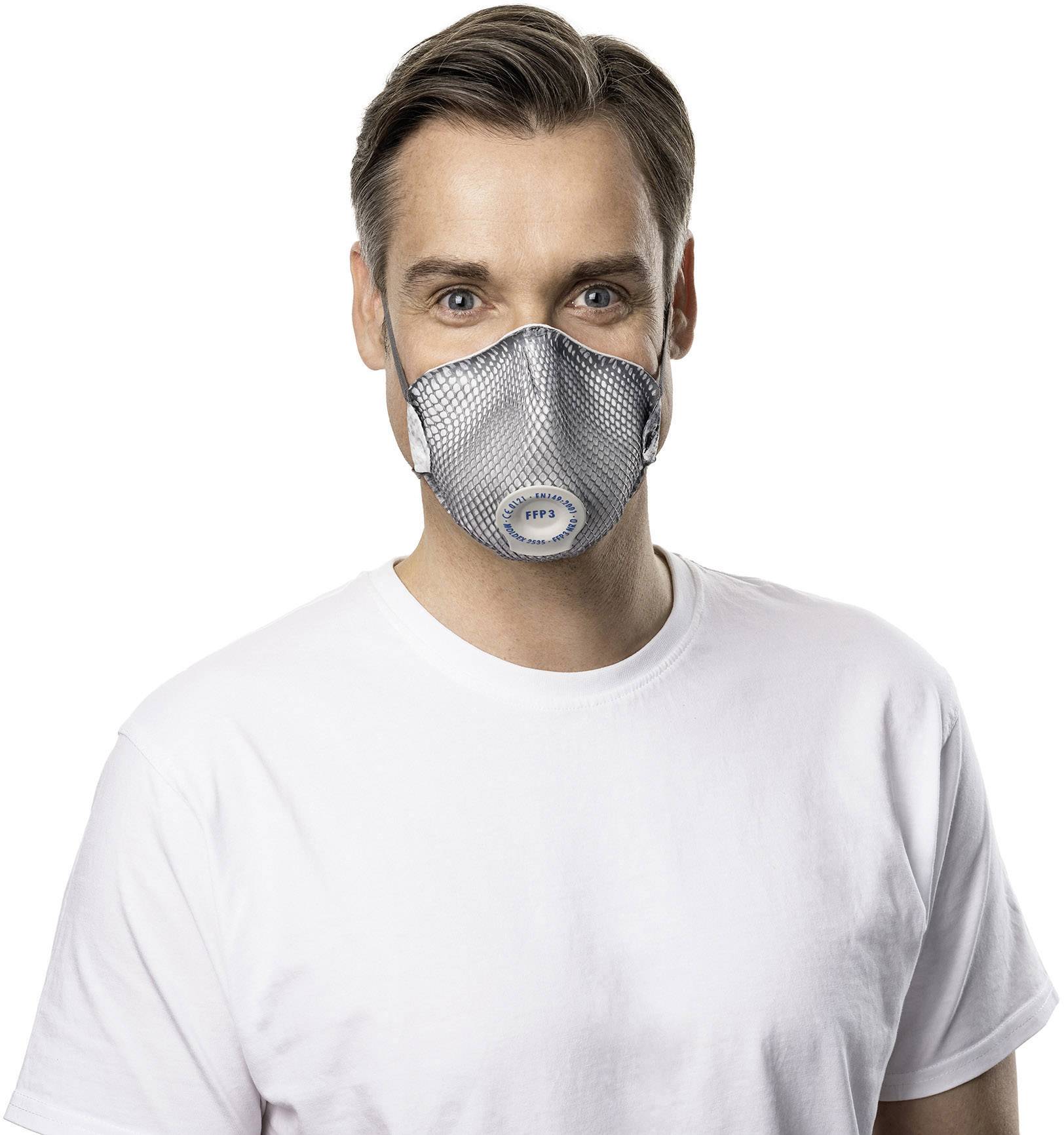 Ein Mann trägt eine graue Atemschutzmaske und ein weißes T-Shirt, blickt freundlich in die Kamera.