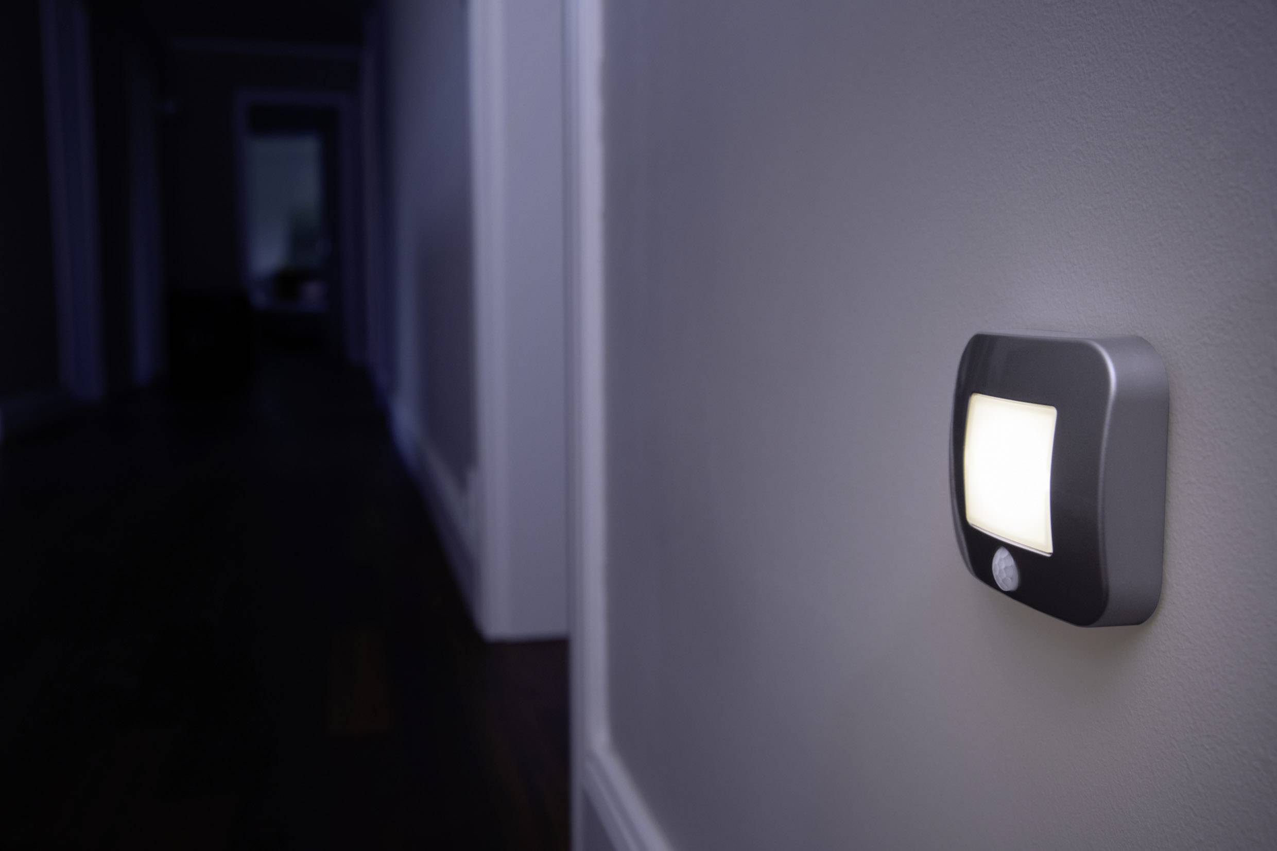 Ein Nachtlicht mit Bewegungsmelder leuchtet einen dunklen Flur aus. Es befindet sich an der Wand auf halber Höhe.