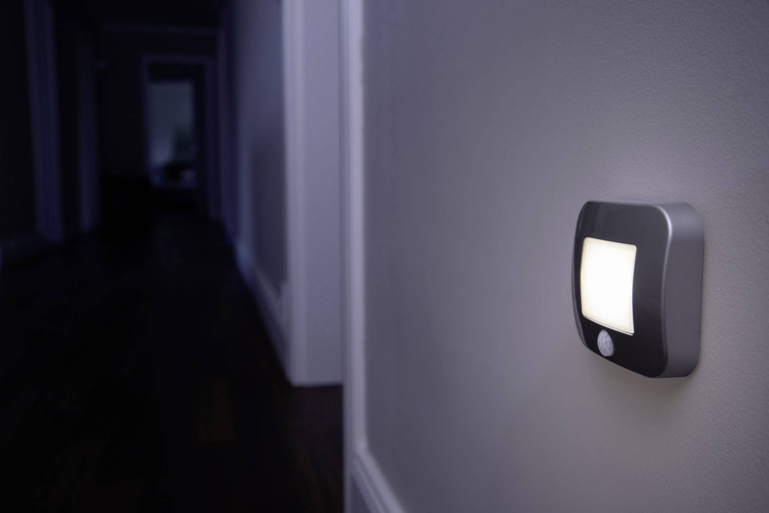 Nachtlicht mit Bewegungssensor an der Wand beleuchtet einen dunklen Flur, um Orientierung und Sicherheit im Dunkeln zu bieten.