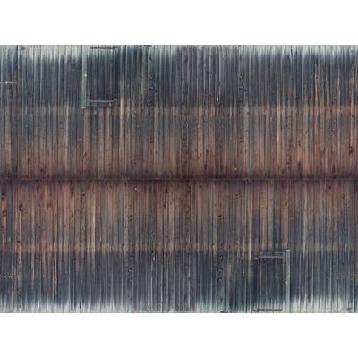 Alte, verwitterte Holzwand mit vertikalen Brettern und einem verblassten braun-grauen Farbverlauf.