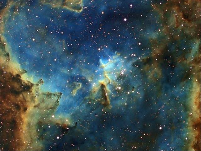 Ein farbenfrohes Bild des Weltalls zeigt einen blauen und orangefarbenen Nebel mit leuchtenden Sternen auf dunklem Hintergrund.