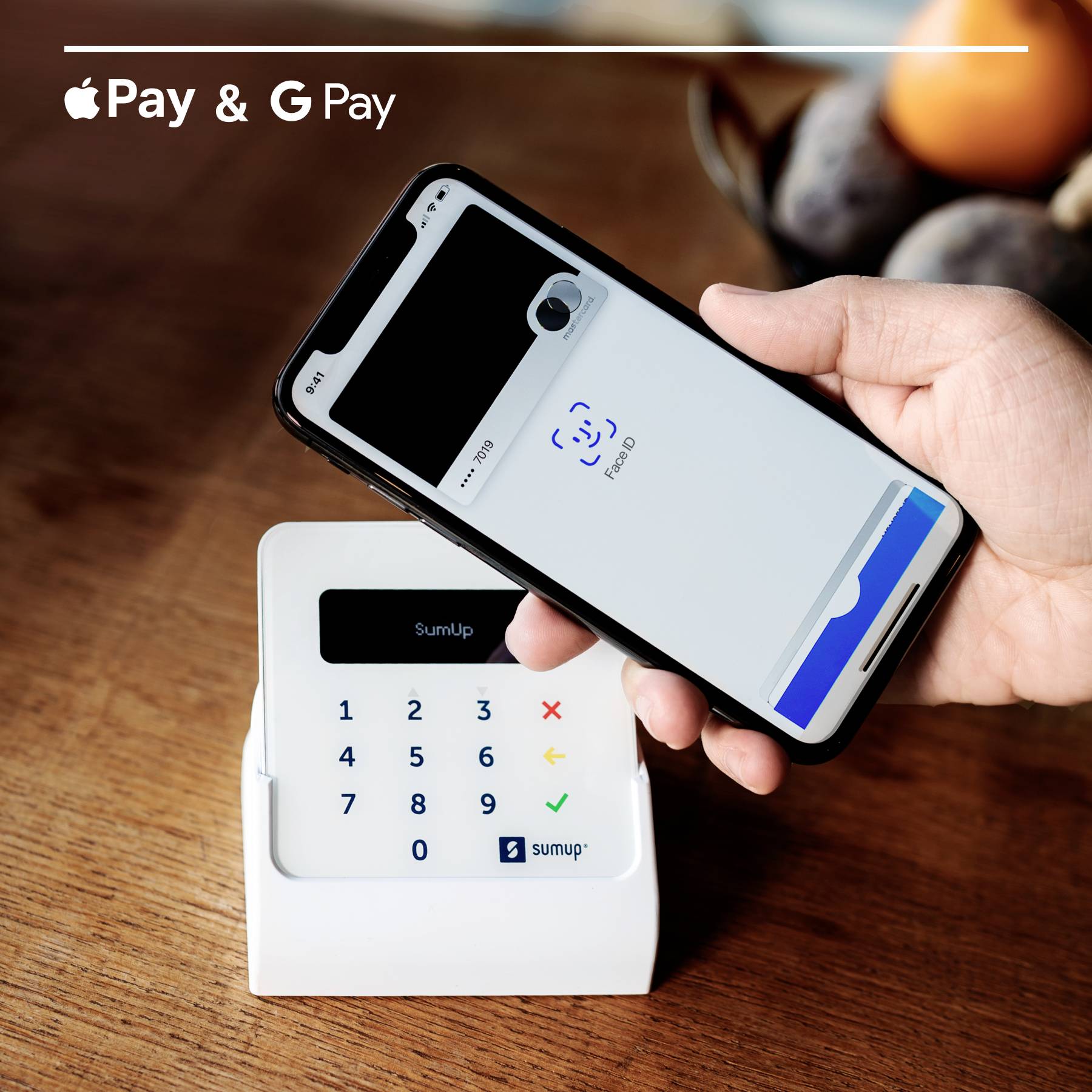 Eine Hand hält ein Smartphone mit aktiviertem Bezahlvorgang über ein SumUp-Kartenlesegerät. Oben links sind 'Apple Pay' und 'Google Pay' Logos.