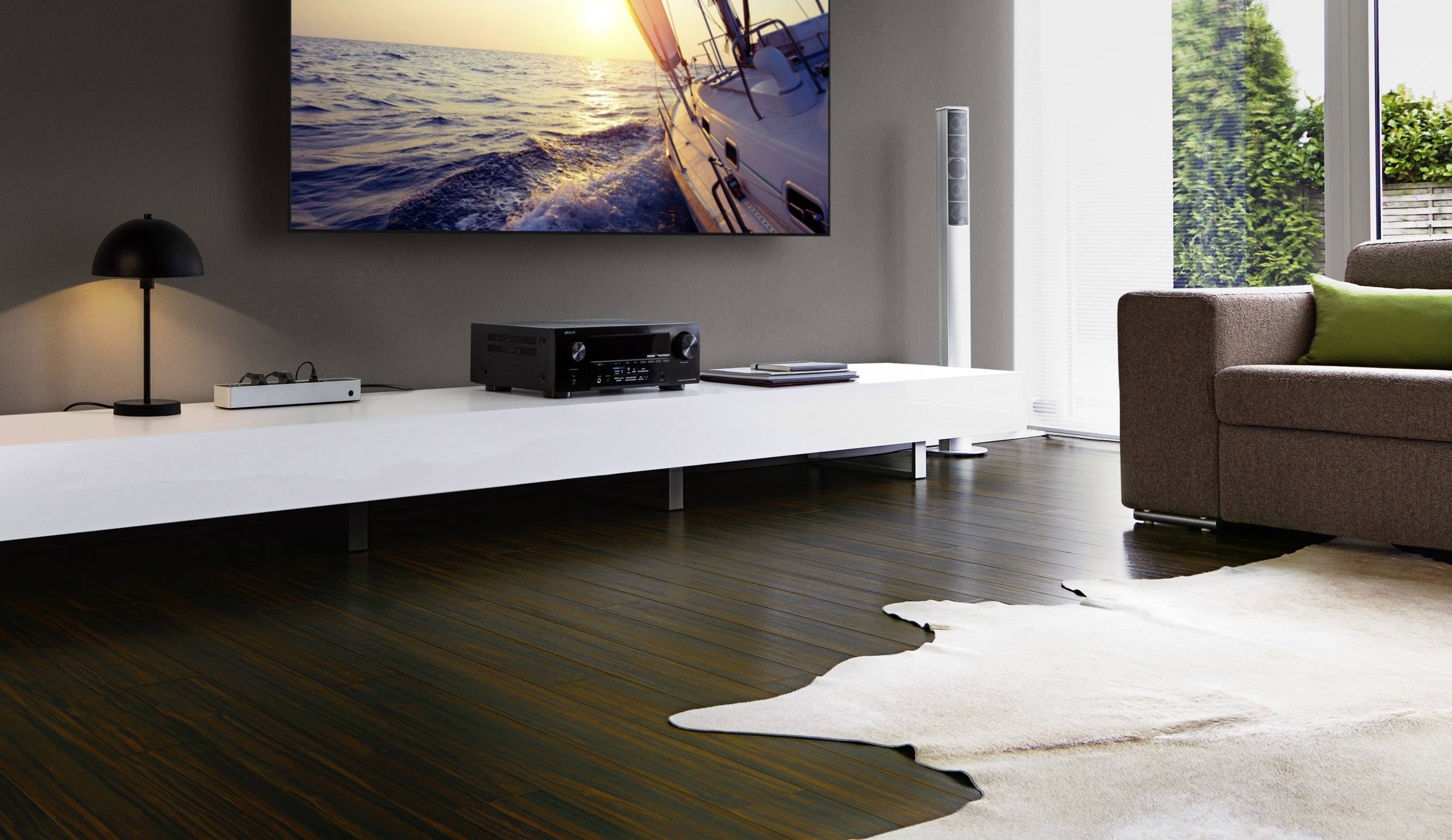 Modernes Wohnzimmer mit einem großen Fernseher an der Wand, der ein Segelboot auf dem Meer zeigt. Elegante Dekoration und Holzboden verleihen dem Raum eine gemütliche Atmosphäre.