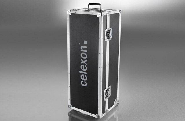 Ein silberner Transportkoffer mit schwarzen Seiten und weißen Verstärkungen. Auf der Seite steht 'celexon'. Der Koffer hat Griffe und Metallecken.