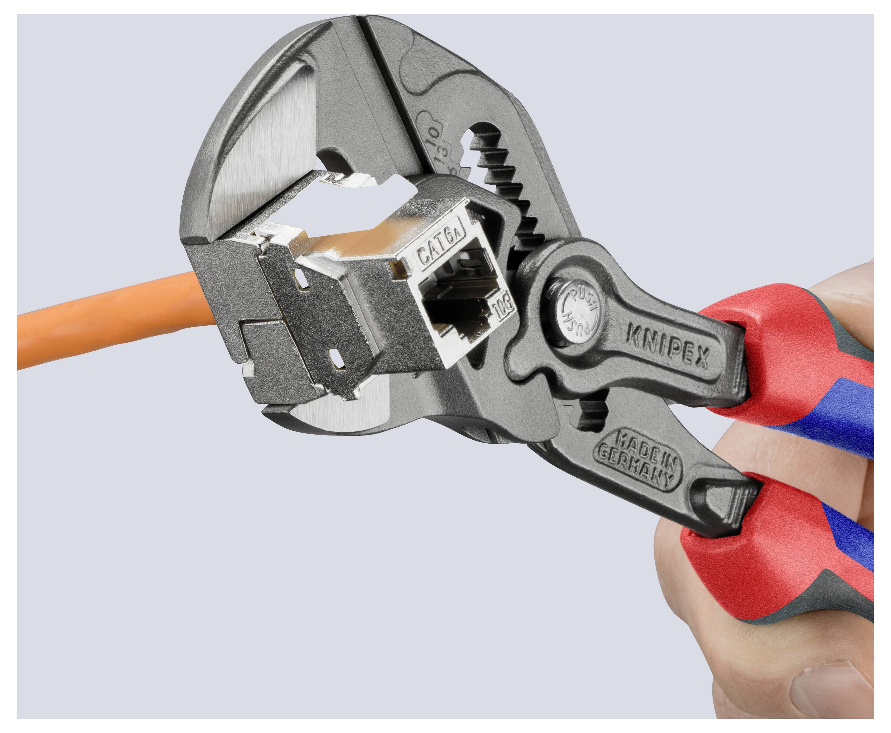 Eine Hand hält eine Zange, die ein orangefarbenes Kabel mit der Aufschrift "CAT6A" greift, vor einem hellgrauen Hintergrund. Die Zange ist mit Markierungen von Herstellerangaben versehen.