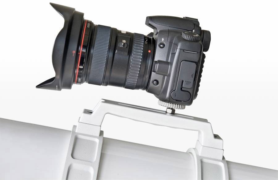 Eine Kamera mit einem großen Objektiv ist auf einem weißen Rohr montiert, möglicherweise zur Fotografie oder Videoaufzeichnung.