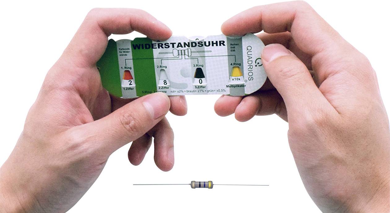 Zwei Hände halten eine 'Widerstandsuhr', um einen Widerstandswert zu bestimmen, während ein Widerstand auf dem Tisch liegt.