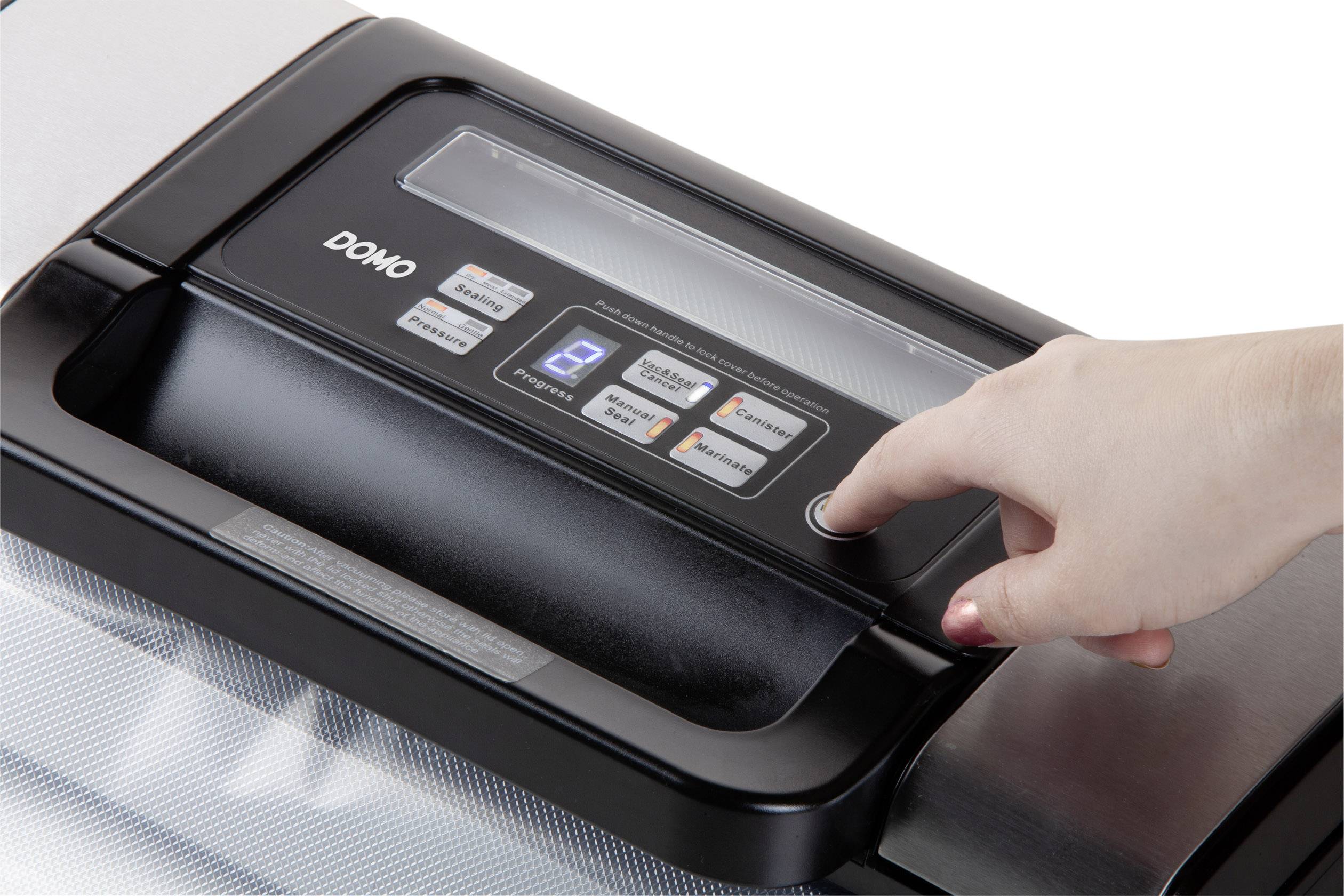 Eine Hand drückt den Knopf eines Vakuumiergeräts. Das Bedienfeld zeigt verschiedene Tasten und ein Display.