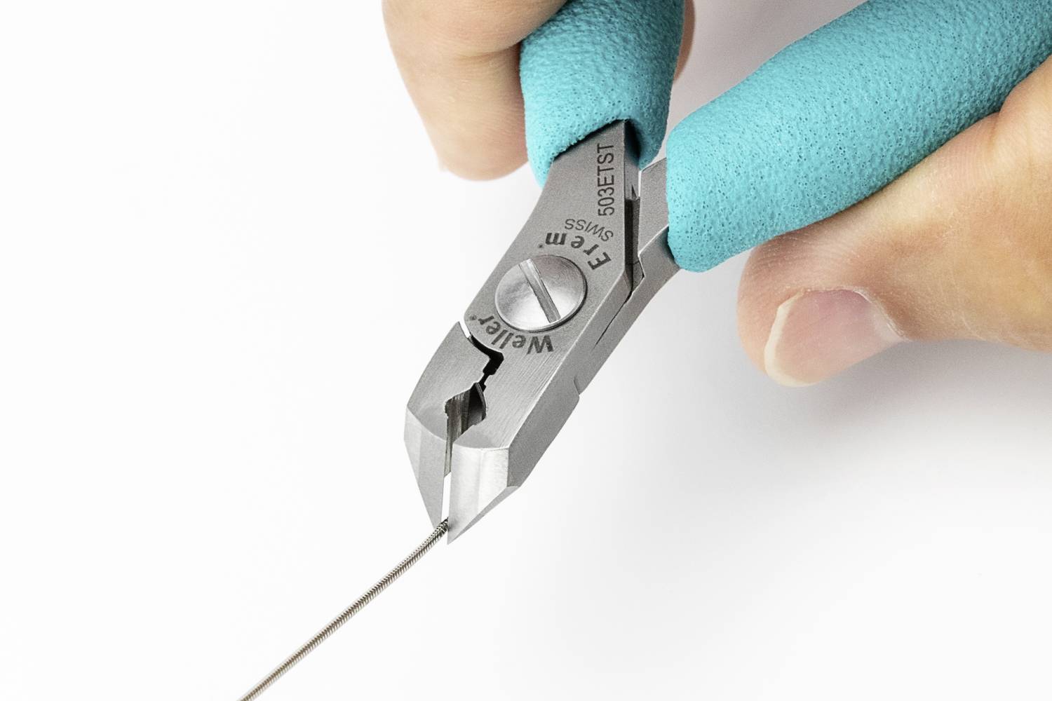 'Nahaufnahme einer Hand, die mit einer blauen Zange einen dünnen Draht schneidet.'