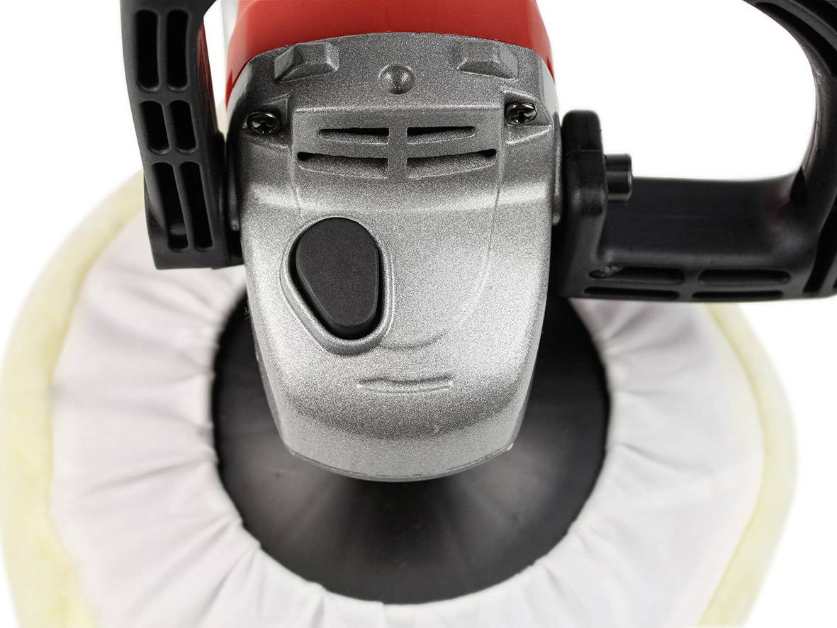 Eine elektrische Poliermaschine mit rotem Griff und silbernem Kopf, auf einer runden Polierscheibe platziert.