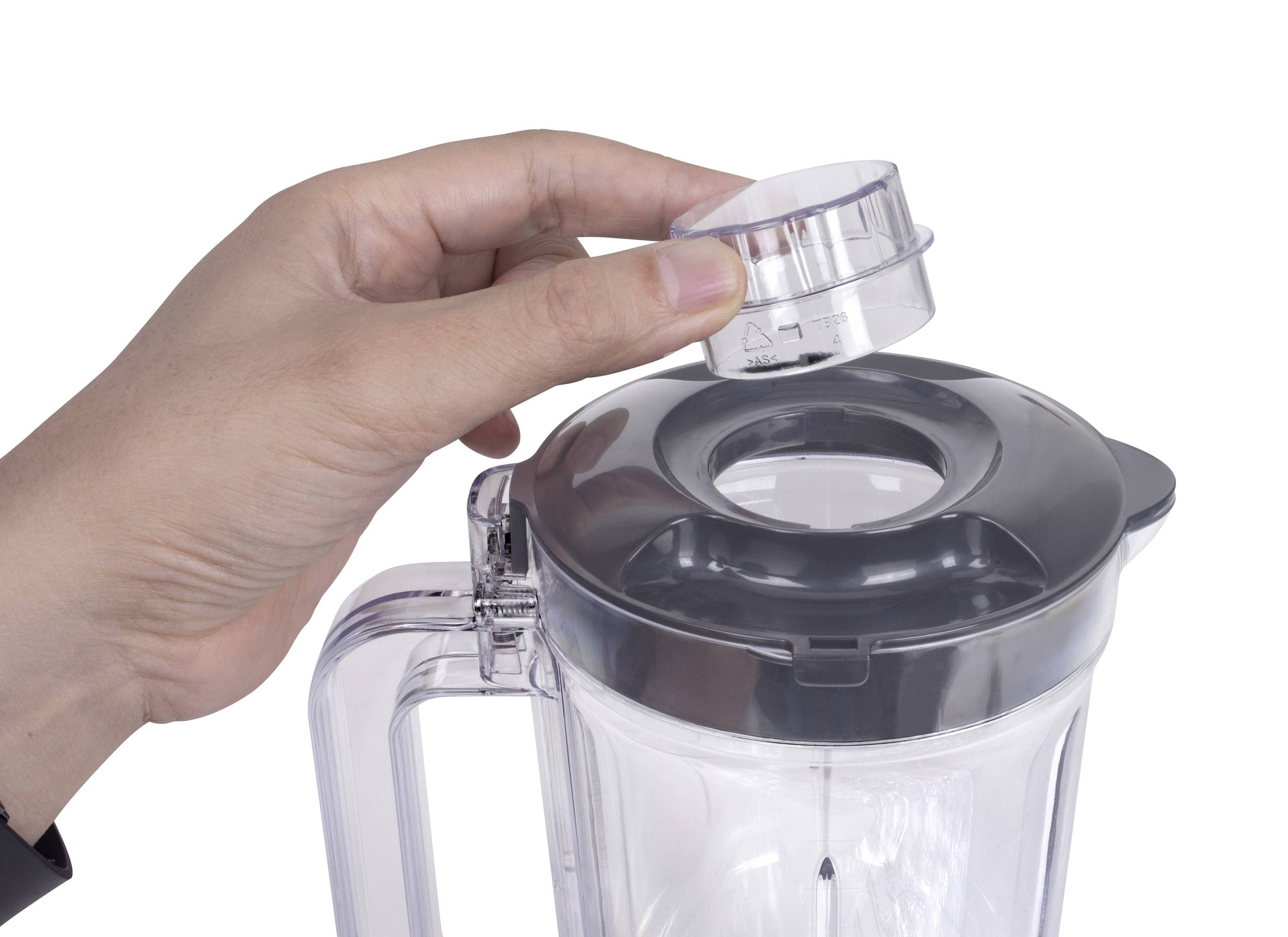 Hand hält einen Deckel über einem offenen Mixer. Der Deckel wird zum Verschließen des Mixers vorbereitet.