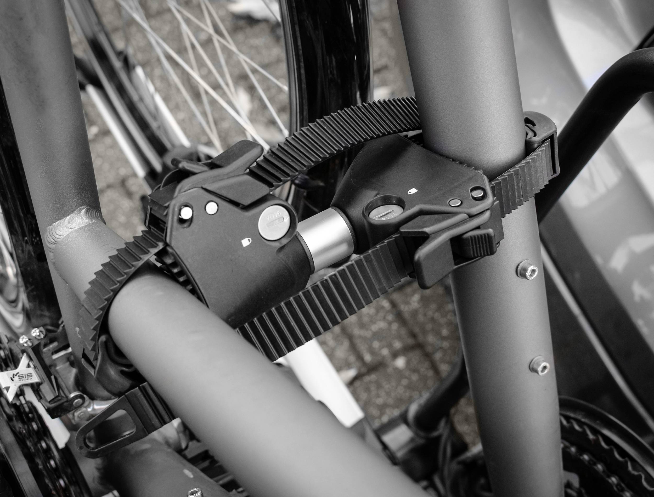 Ein Fahrrad ist mit einem robusten Schloss gesichert, das um den Rahmen und ein anderes festes Objekt befestigt ist.