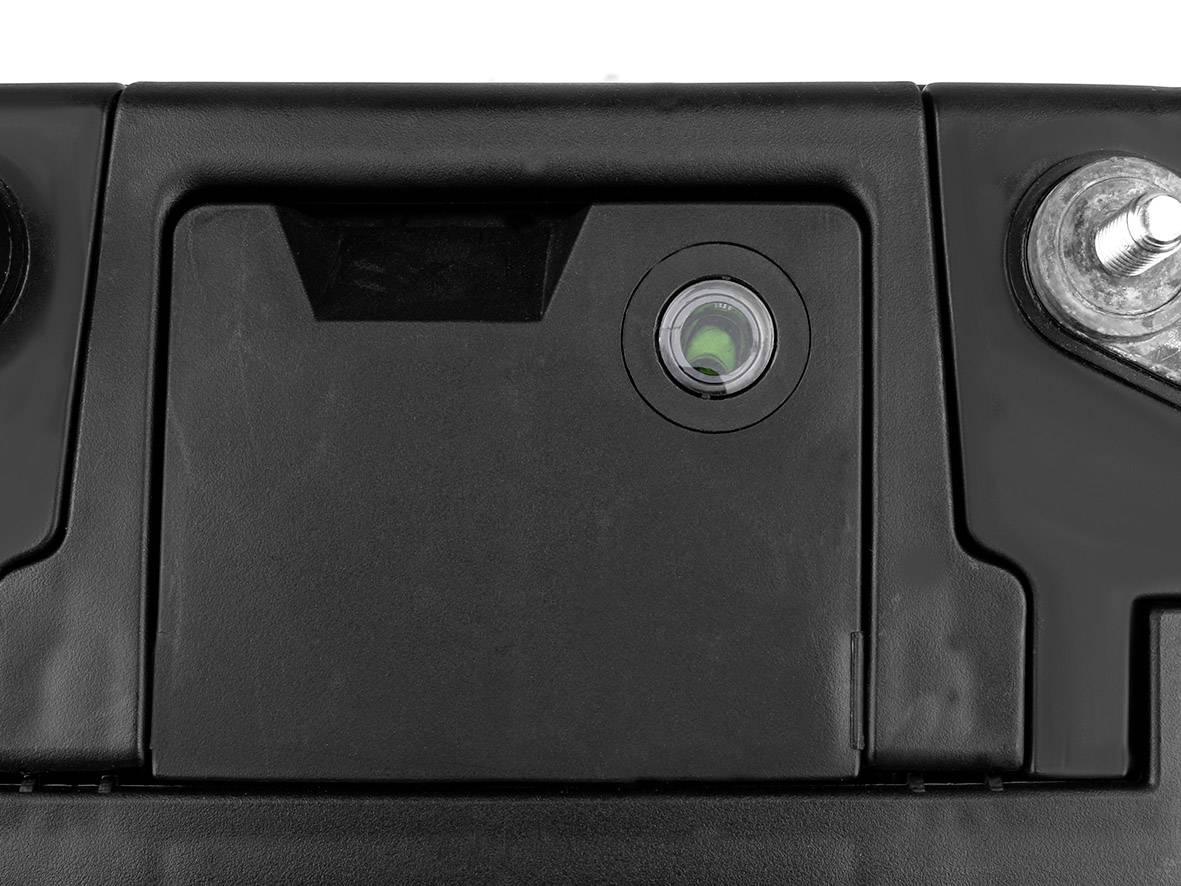 Eine schwarze Autobatterie von oben mit Plus- und Minuspolen sichtbar.