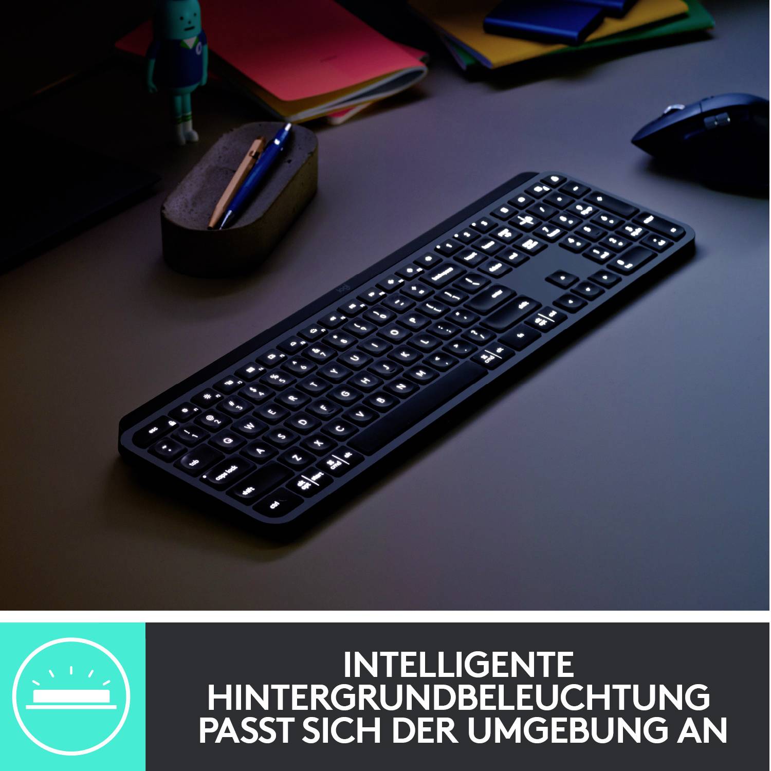 Eine beleuchtete Tastatur liegt auf einem Schreibtisch. Darunter steht der Text: 'Intelligente Hintergrundbeleuchtung passt sich der Umgebung an'.