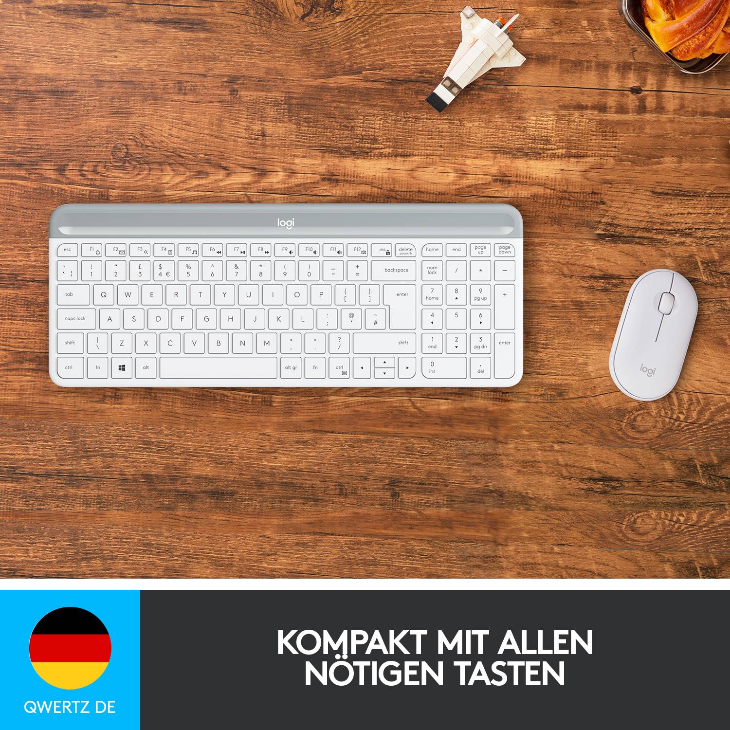 Eine kompakte, weiße QWERTZ-Tastatur und Maus auf Holzuntergrund. Unten steht: 'Kompakt mit allen nötigen Tasten'. Links das deutsche Flaggen-Icon.