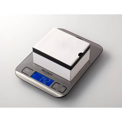 Eine digitale Küchenwaage zeigt ein Gewicht von 1,42 kg an. Auf der Waage liegt ein quadratisches, weißes Paket.