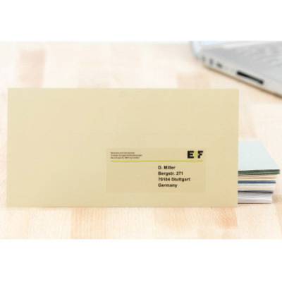 Briefumschlag mit Adressetikett, adressiert an 'D. Müller, Bergerstr. 27, 70184 Stuttgart, Germany', liegt auf einem Tisch.
