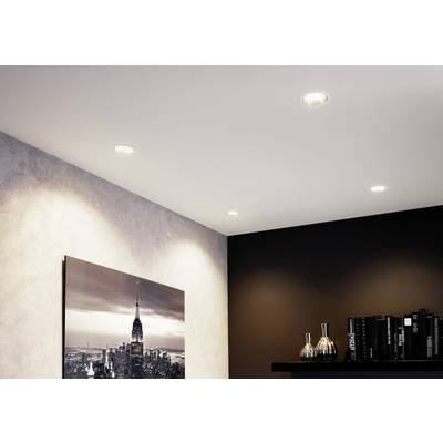 Ein Wohnzimmer mit eingelassenen Deckenleuchten, einem New York-Bild an der Wand und einem Regal mit Büchern und Metallvasen.