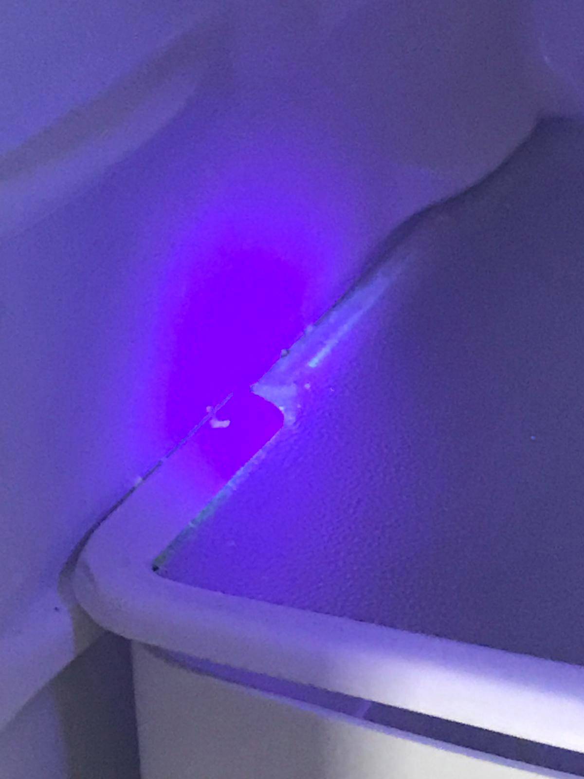 'Nahaufnahme eines Kunststoffecks mit blauem Licht beleuchtet, das feine Details der Oberfläche hervorhebt.'