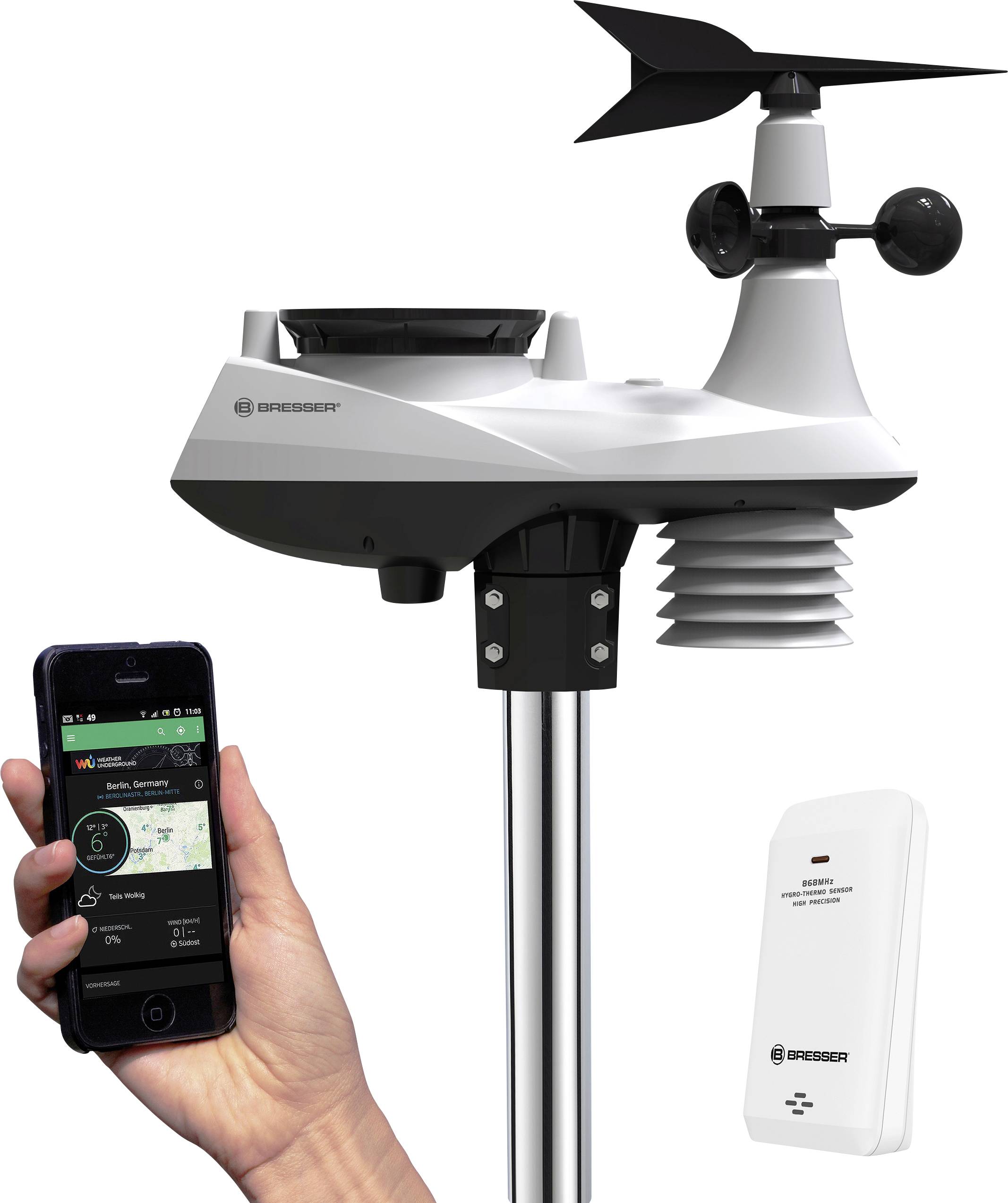 Eine Wetterstation mit Windmesser und Thermometer. Eine Hand hält ein Smartphone mit Wetter-App. Markengerät, modernes Design.