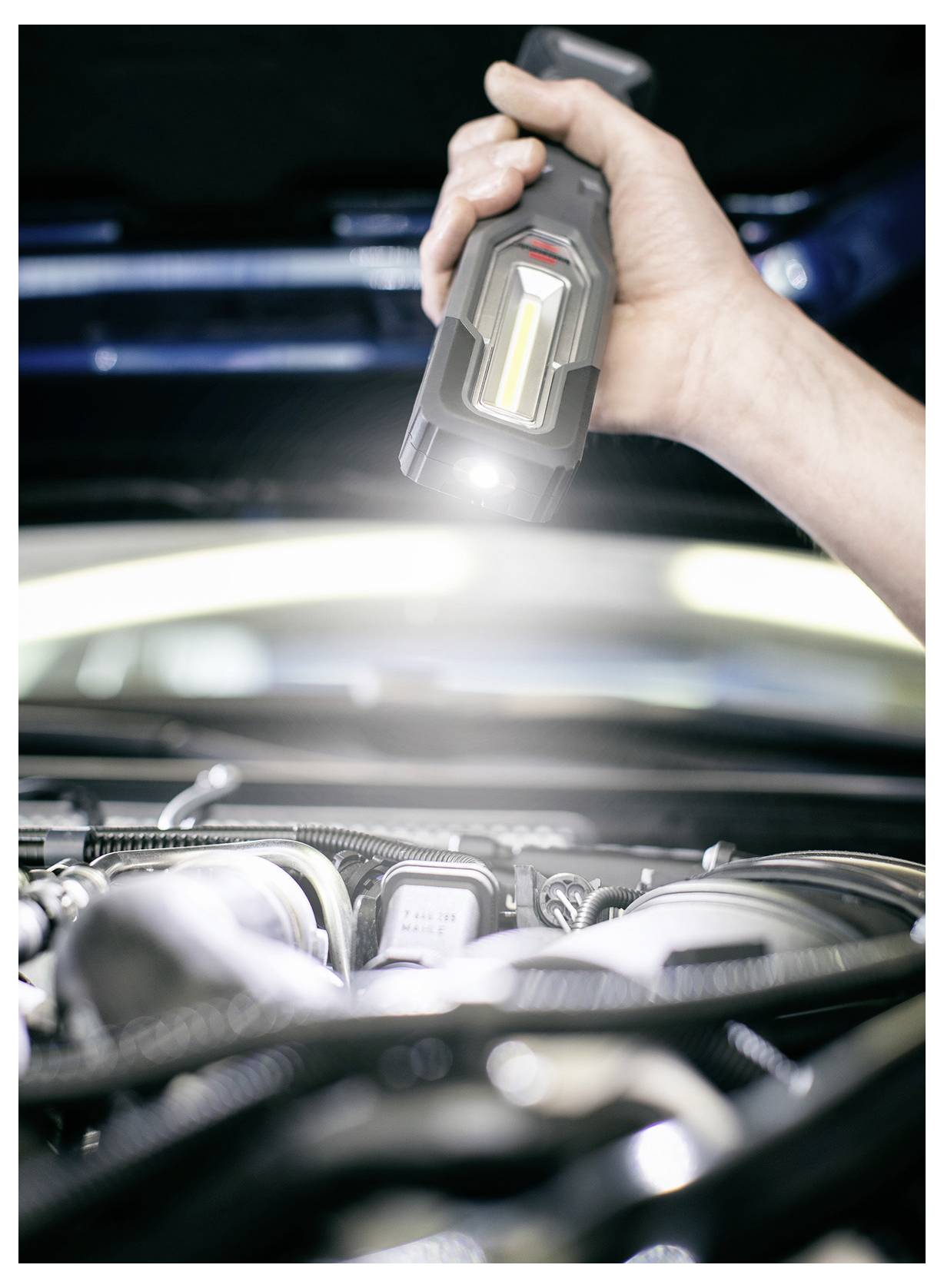 Tragbare Inspektionsleuchte, die einen Automotorraum während einer Inspektion oder Reparatur beleuchtet.