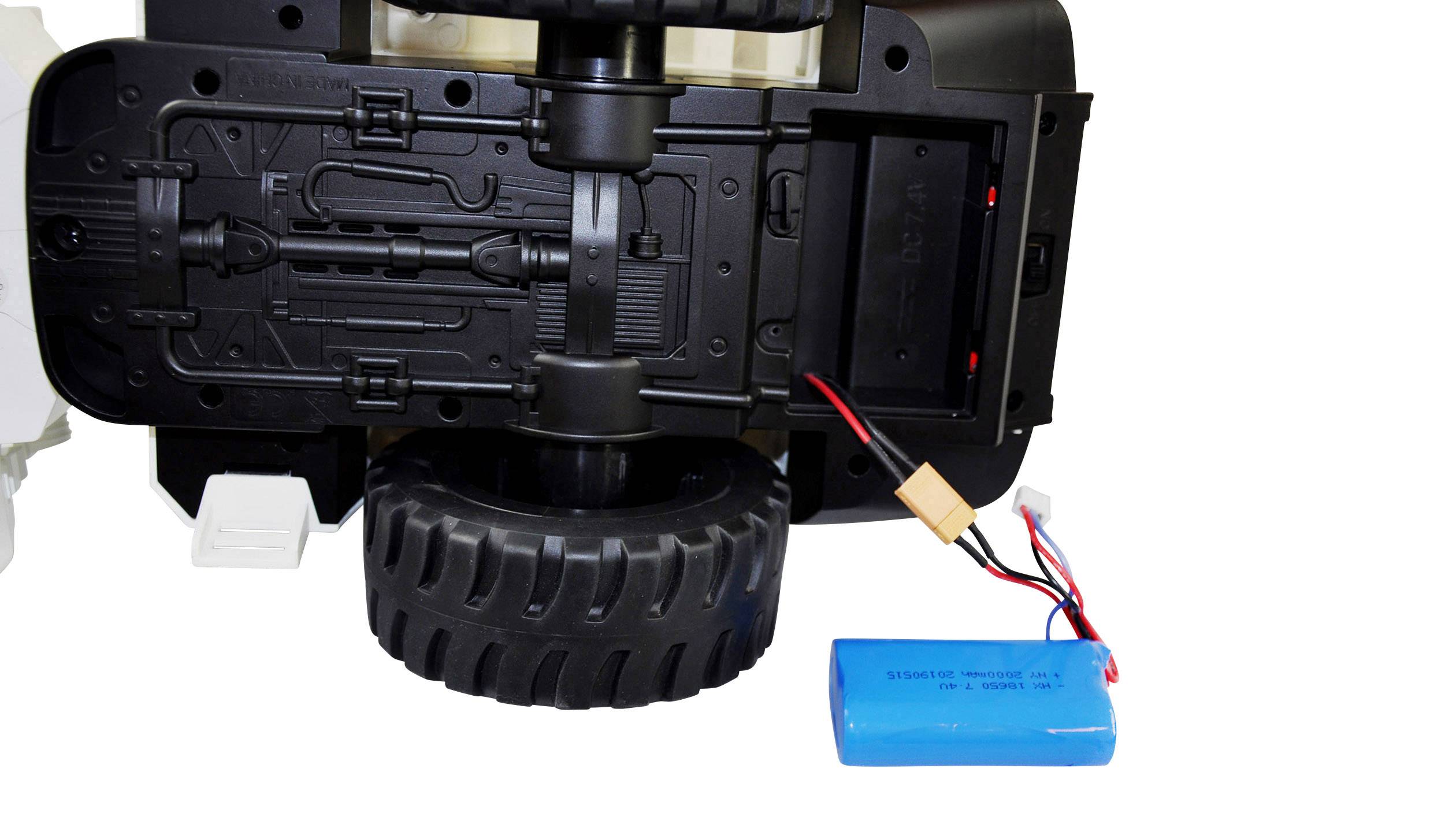 Unterseite eines kleinen Fahrzeugs mit großem schwarzen Reifen; ein blaues Akkupack liegt daneben, verbunden mit Kabeln.