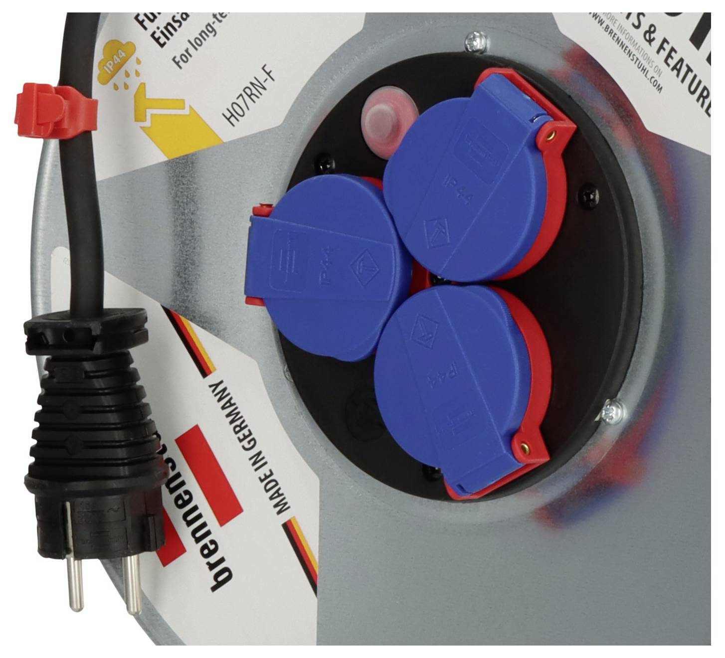 Nahaufnahme einer industriellen Steckdose mit drei blau abgedeckten Steckdosen und einem schwarzen Stecker auf der linken Seite, die ein robustes Anschlussfeld zeigt.