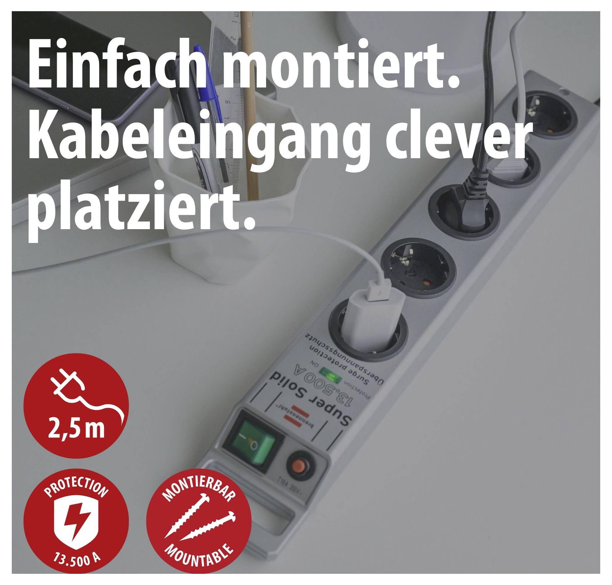 Steckdosenleiste unter dem Schreibtisch mit Kabelzuführung; Text: 'Einfach montiert. Kabeleingang clever platziert.' sowie 2,5 m, 13.500 A, montierbar.