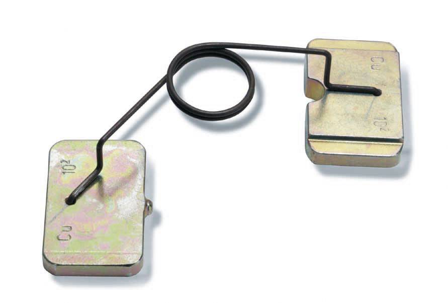 Zwei metallische Gewichte, verbunden durch einen gebogenen Draht mit einer kreisförmigen Spirale in der Mitte, auf weißem Hintergrund.
