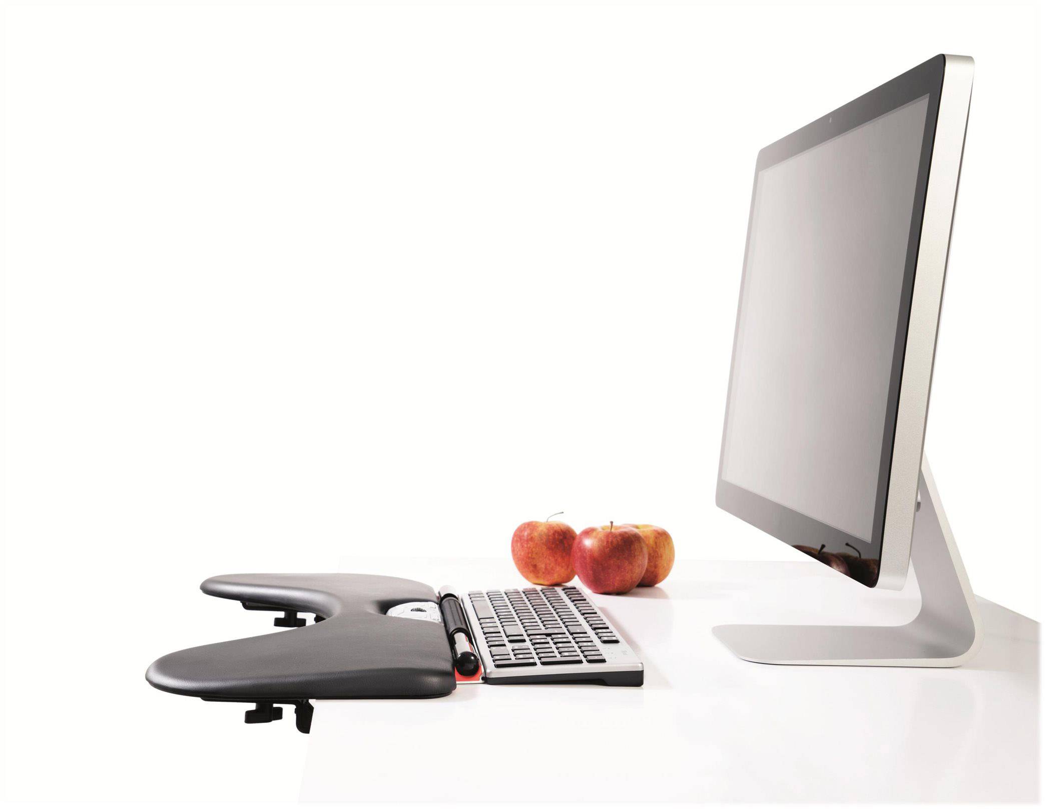 Ein Desktop-Monitor und eine Tastatur auf weißem Tisch, daneben liegen drei rote Äpfel; modernes und minimalistisches Büroszenario.