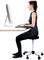 Eine Frau sitzt gerade an einem Schreibtisch vor einem Computerbildschirm und arbeitet mit einer ergonomischen Haltung.