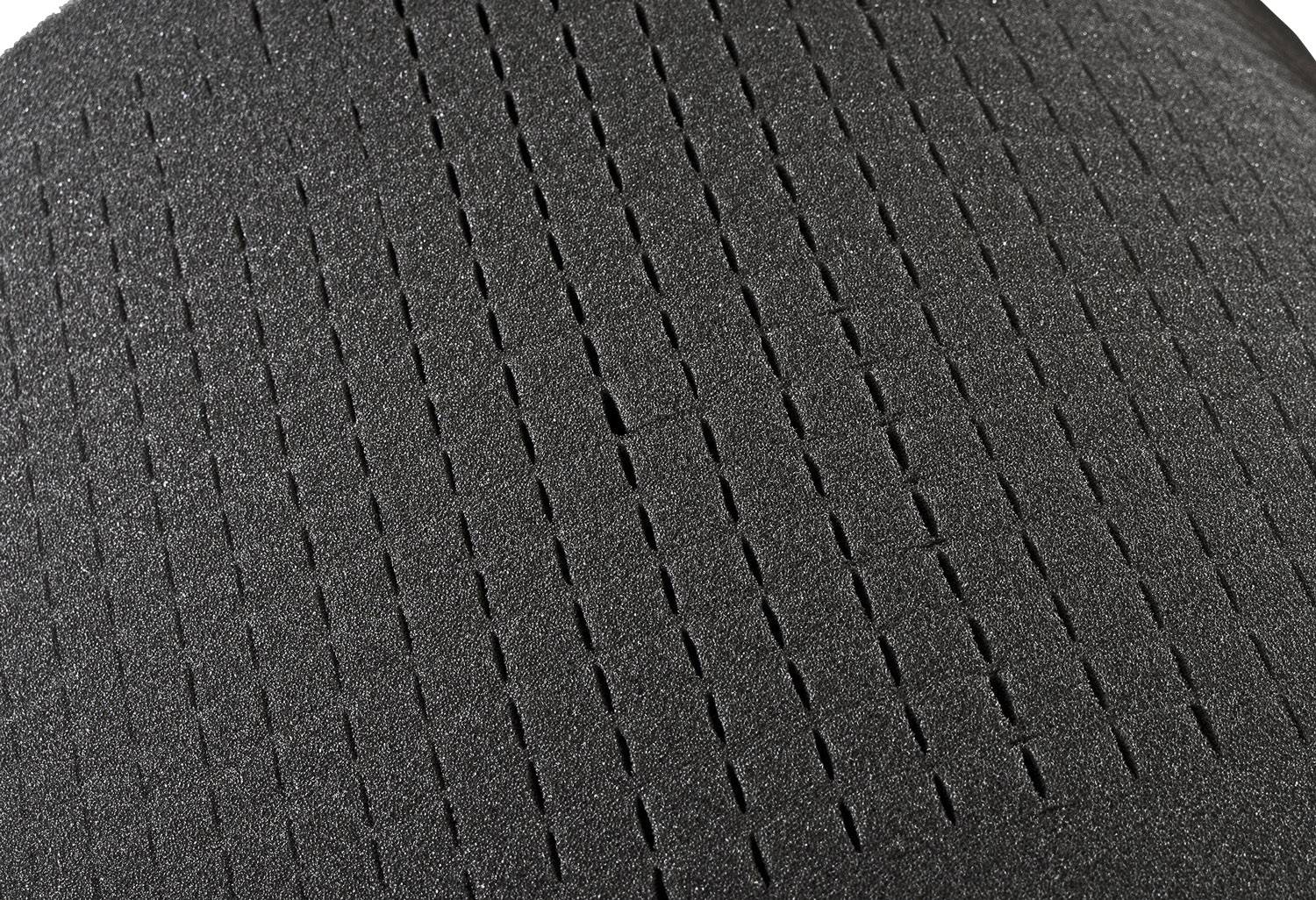 Schwarze, strukturierte Oberfläche mit parallelen Rillen, die möglicherweise Teil eines größeren Designs oder Objekts ist.