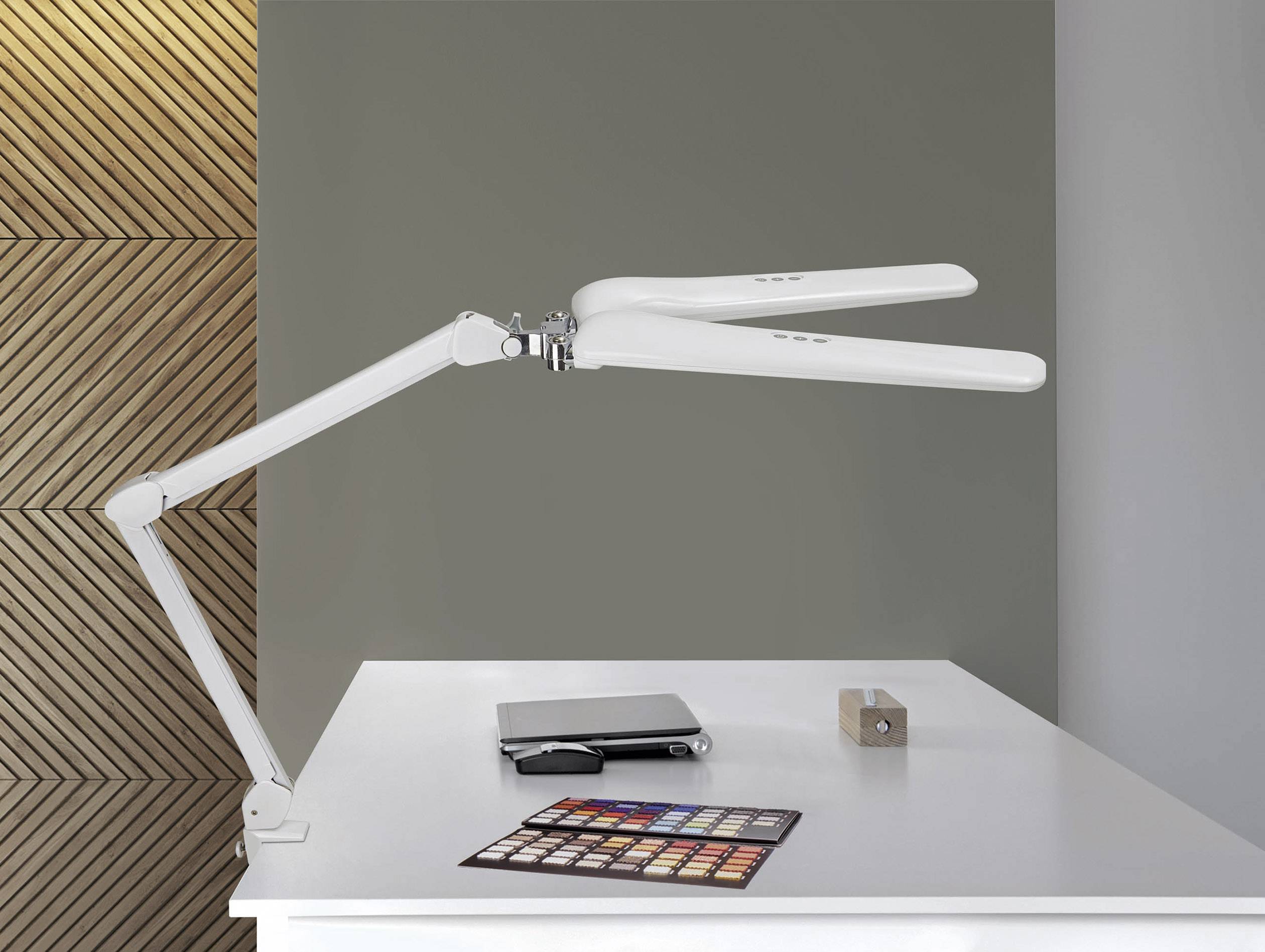 Eine weiße Tischlampe mit einem langen, verstellbaren Arm ist auf einem weißen Schreibtisch neben einem Laptop und Farbpalette platziert.