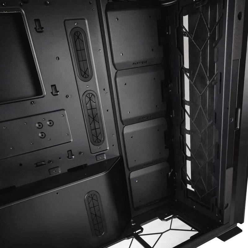Schwarzer Computergehäuseinnenraum mit mehreren vertikalen Laufwerksschächten, Kabeldurchführungen und einem Lüftungsgitter.