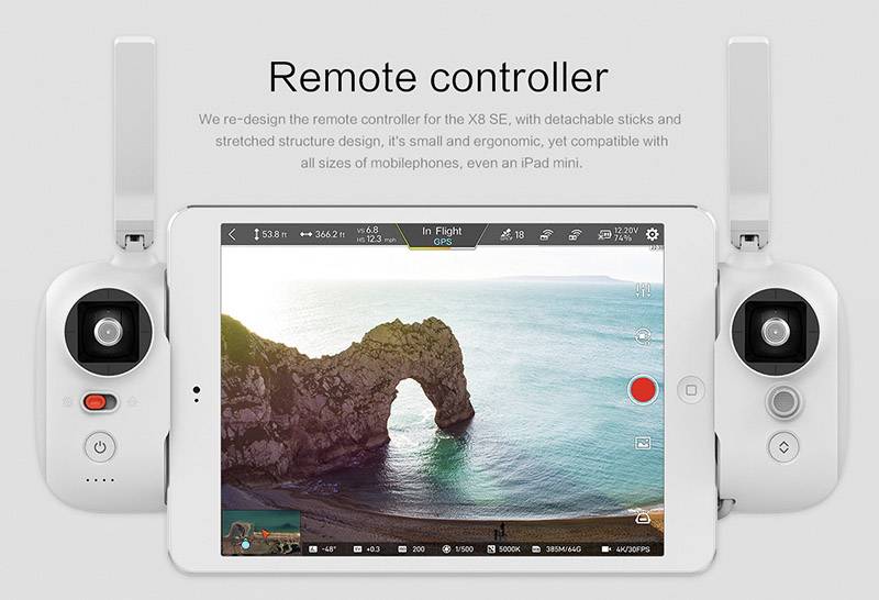 Eine Fernbedienung mit Tablet-Halterung zeigt auf dem Bildschirm ein Live-Video von einer Küste mit einem Felsbogen im Meer.