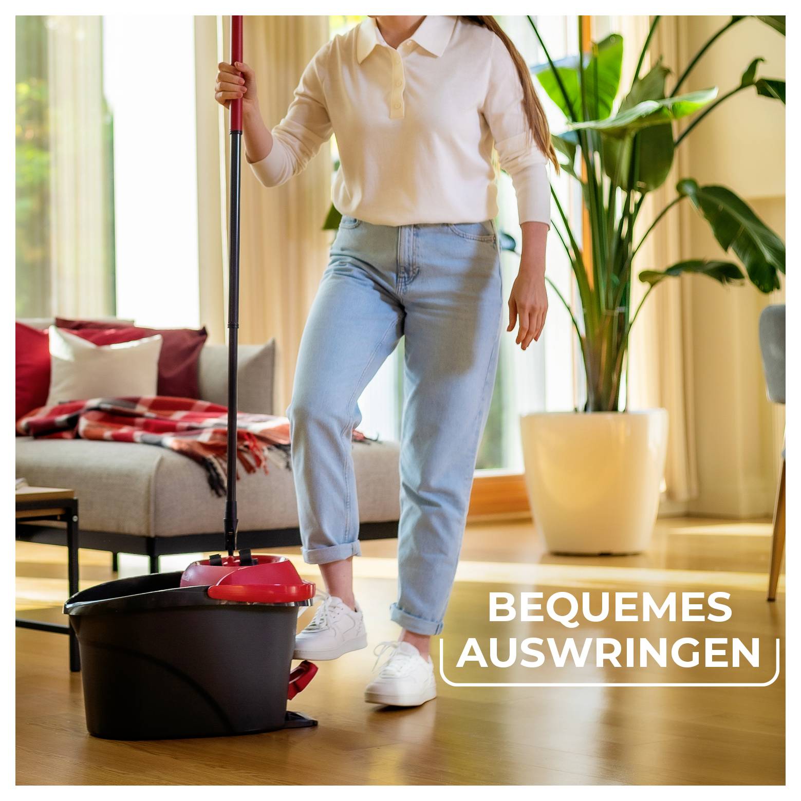 Person wischt einen Wohnzimmerboden mit einem Eimer; Text lautet „BEQUEMES AUSWRINGEN".