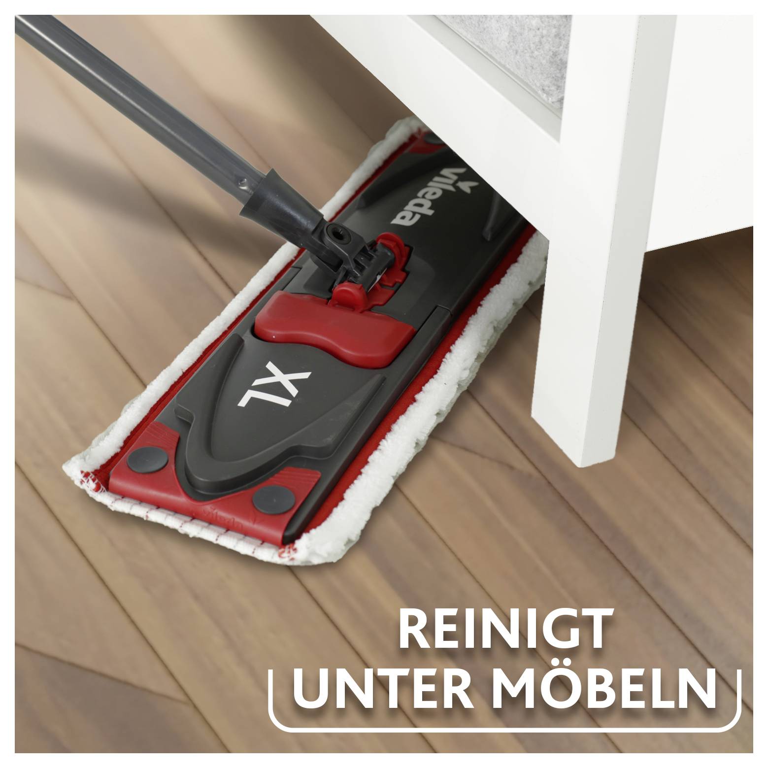 Flacher Mopp reinigt unter Möbeln auf einem Holzboden, mit Text „REINIGT UNTER MÖBELN", das anzeigt, dass er unter Möbeln reinigt.