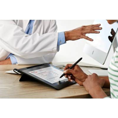 Eine Person schreibt auf einem Tablet mit einem Stift, während eine andere Person in einem weißen Kittel auf einen Computerbildschirm zeigt.