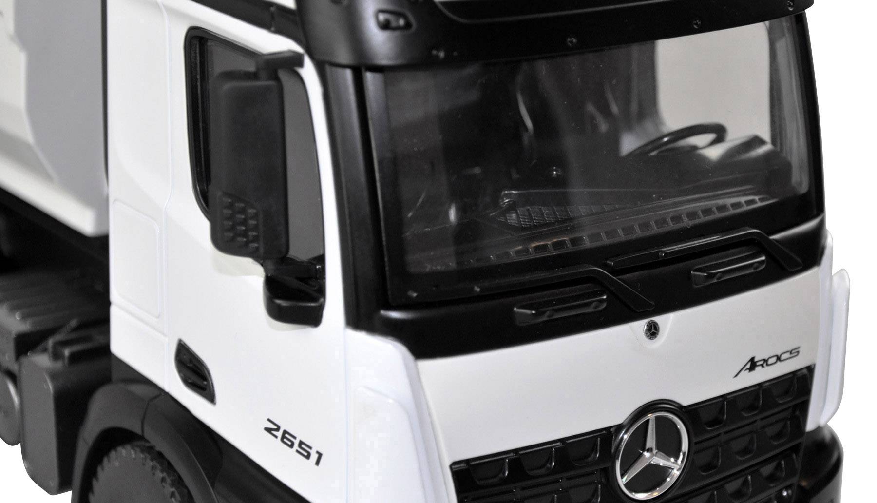 Spielzeugmodell eines weißen Lastwagens mit schwarzem Dach. Markenschriftzug 'Actros' und Logo auf der Front erkennbar.