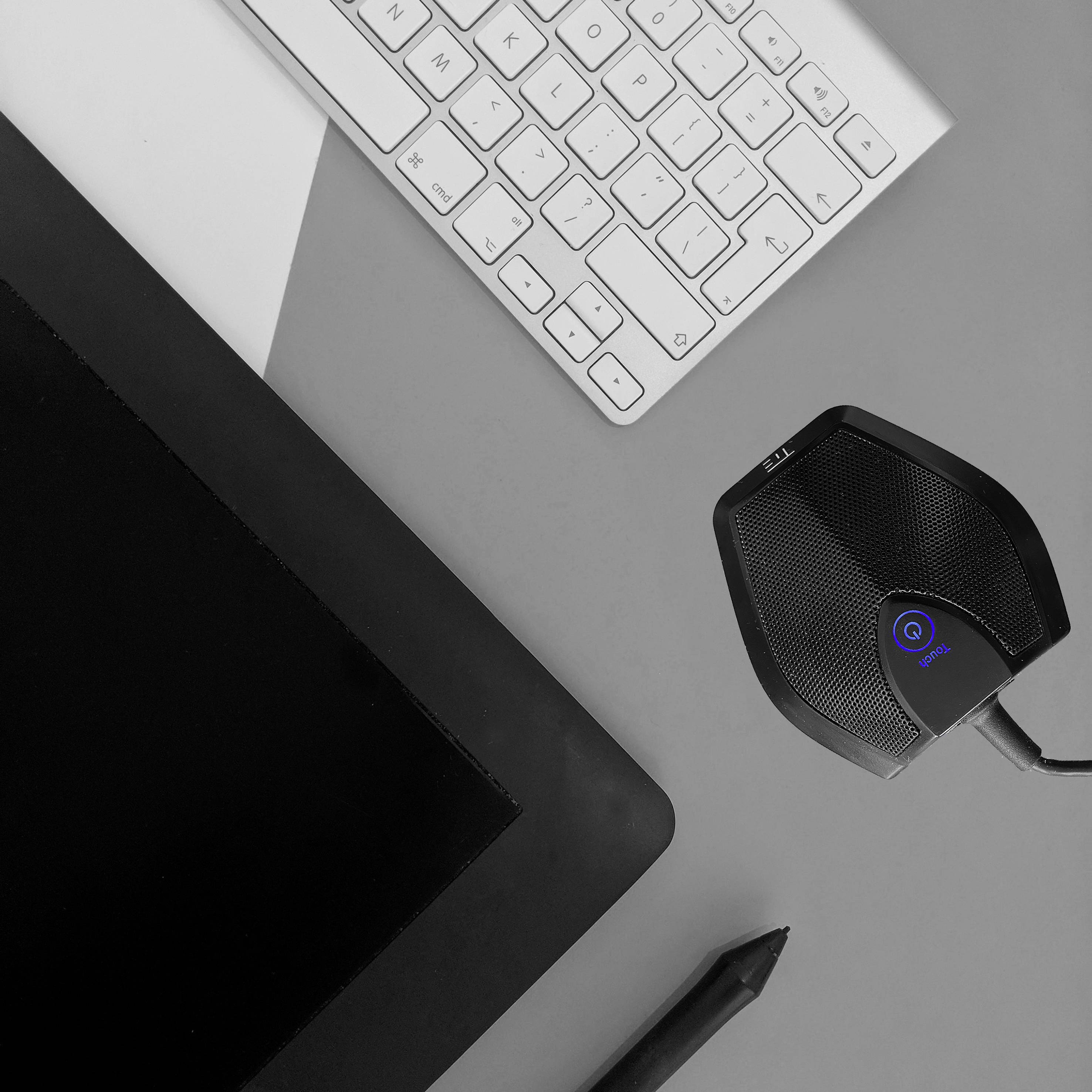 Grafiktablett, Mikrofon und Tastatur auf einem Tisch angeordnet. Ideal für digitale Kreativarbeiten.