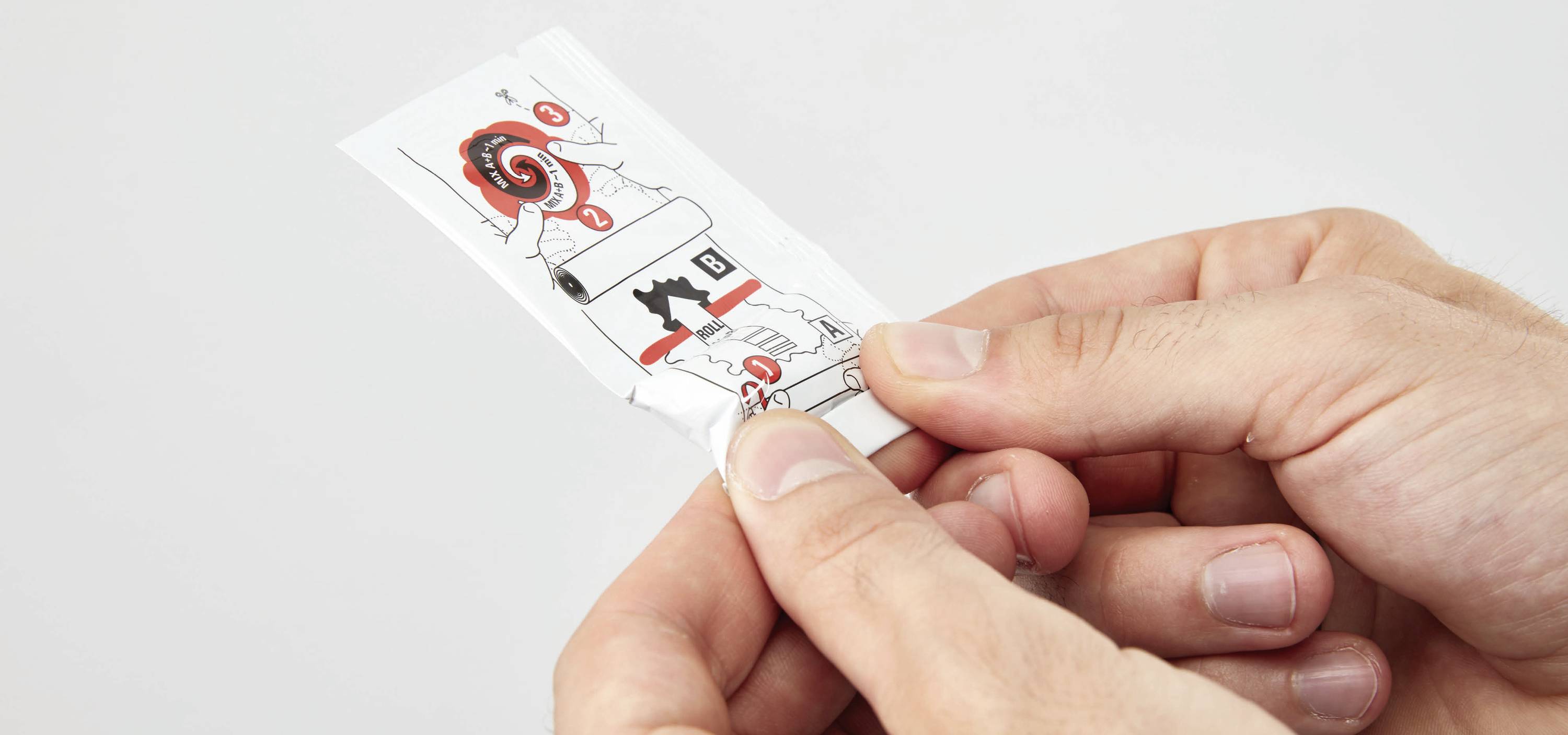 Eine Hand öffnet eine Verpackung mit Anweisungen zur Verwendung. Einfache Illustrationen zeigen diverse Schritte.