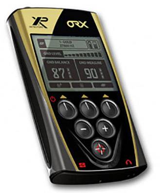 Handgerät für Metalldetektion mit Bildschirm, zeigt 'T-Gold' Modus, Frequenzen und andere Einstellungen an. Schwarzes Gehäuse, goldene Akzente.