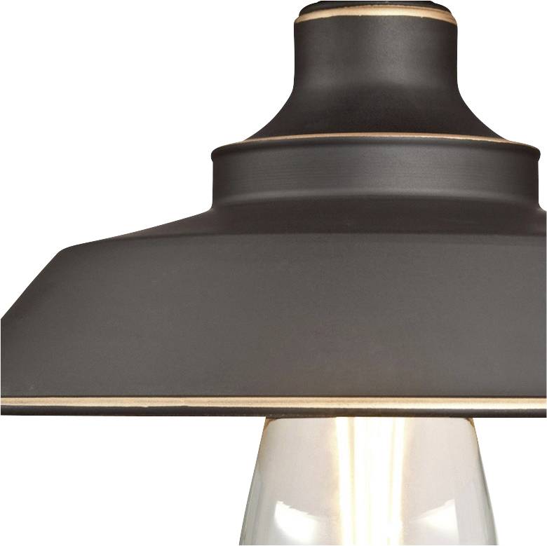 Eine elegante Deckenlampe mit dunklem Schirm und kupferfarbenem Rand, darunter eine leuchtende Glühbirne.