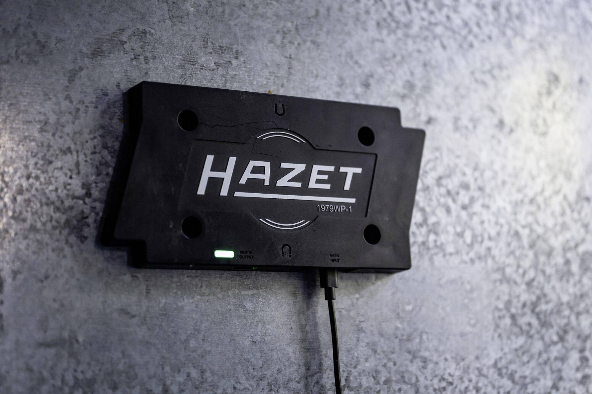 'HAZET'-Marken-Werkzeug an einer Wandhalterung montiert, schwarzes Gehäuse mit Kabelanschluss, geeignet für Werkstattumgebung.