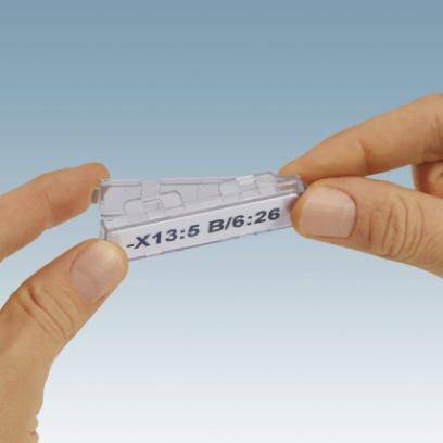 Eine Hand hält ein Plastiketui mit der Aufschrift 'X13:5 B/6:26'.