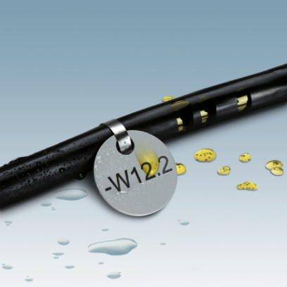 Eine schwarze Leitung mit gelben Ringen und einem silbernen Anhänger, auf dem 'W12.2' steht, liegt auf einer nassen Oberfläche.