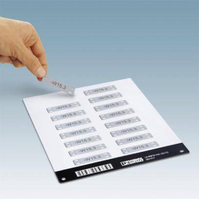 Eine Hand entnimmt ein kleines, rechteckiges Etikett mit der Aufschrift 'W15.3' von einem Blatt mit mehreren identischen Etiketten.