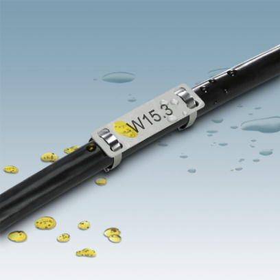 Ein schwarzes Kabel mit einer gelben, mit 'W15.3' beschrifteten Markierung ist mit einem Metallschild gekennzeichnet, umgeben von Wassertropfen.